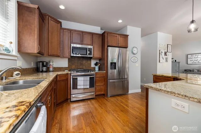 a kitchen with stainless steel appliances granite countertop a refrigerator sink and stove
