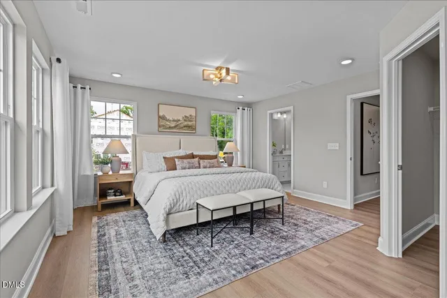 a spacious bedroom with a bed and wooden floor