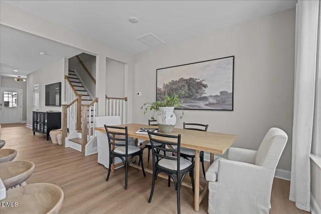 a view of a dining room with furniture wooden floor and a potted plant