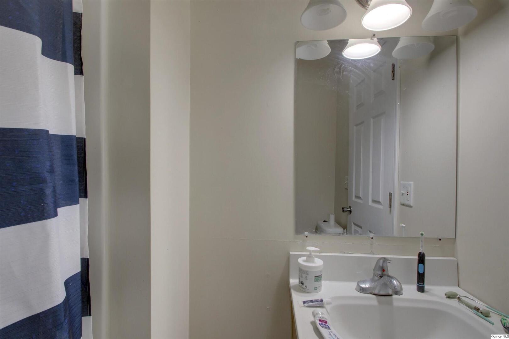 1127 Payson Avenue Quincy, IL 62301 - Photo 16 of 16 a bathroom with a sink and a mirror