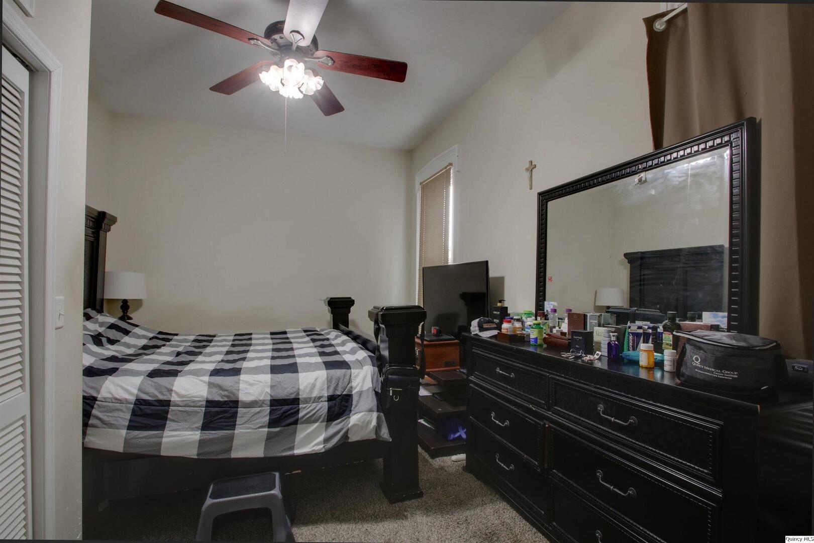 1127 Payson Avenue Quincy, IL 62301 - Photo 6 of 16 a bedroom with a bed and a flat screen tv
