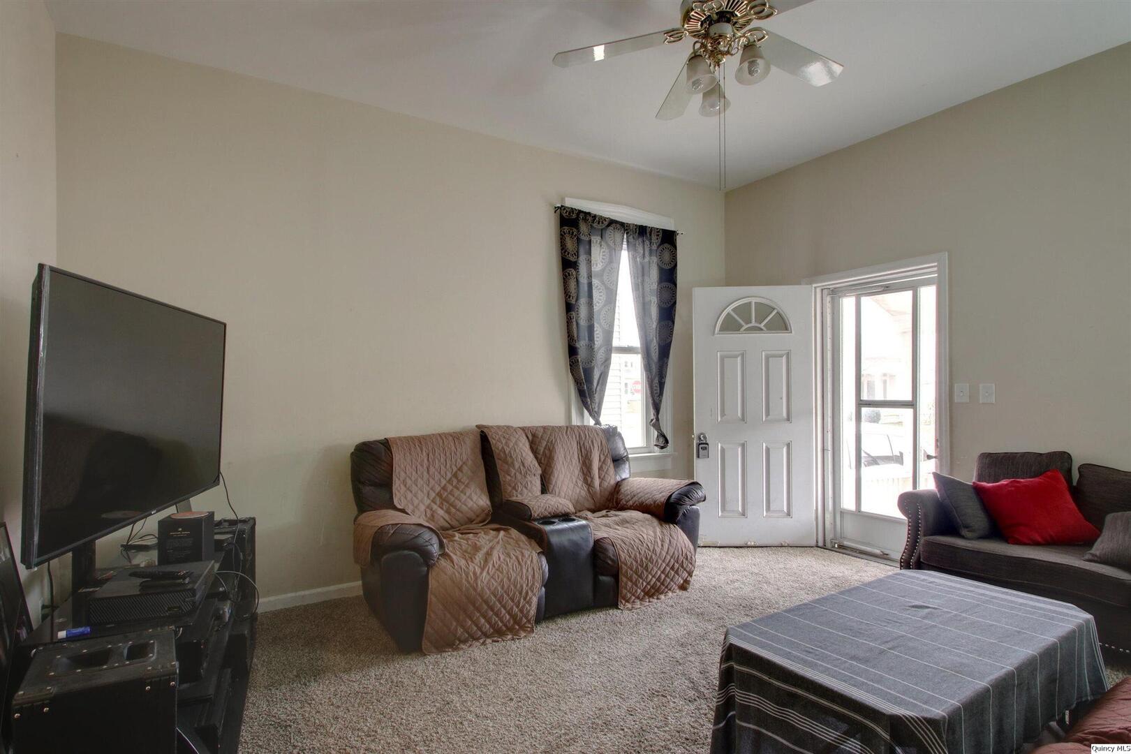 1127 Payson Avenue Quincy, IL 62301 - Photo 9 of 16 a living room with furniture a flat screen tv and a window
