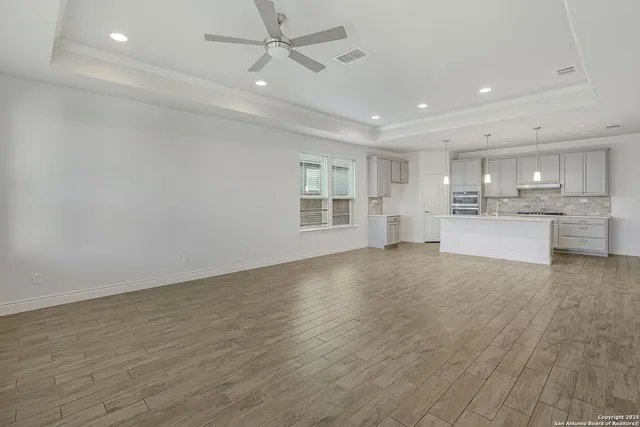 a view of a kitchen with a sink and wooden floor