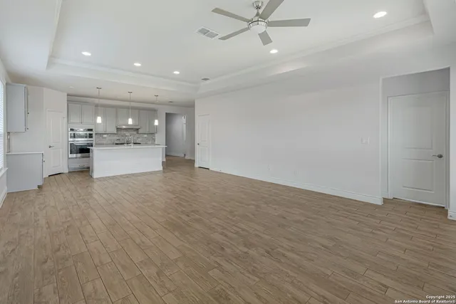 a view of a kitchen with a sink and wooden floor