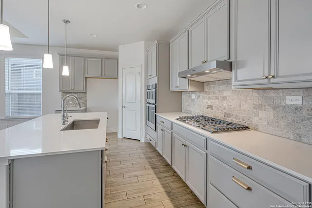 a kitchen with kitchen island granite countertop a sink a stove and refrigerator