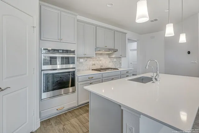 a kitchen with a sink and stove top oven