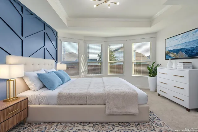 a bedroom with a large bed and a flat tv screen on dresser