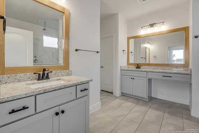 a spacious bathroom with a granite countertop sink a mirror and a