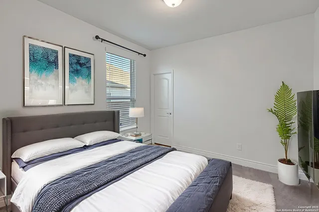 a bedroom with a bed and a potted plant