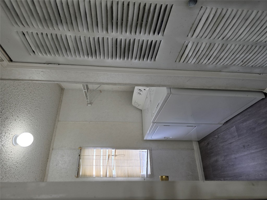 7628 Northview Lane Austin, TX 78724 - Photo 6 of 19 Laundry room with dark wood finished floors, a heating unit, washing machine and dryer, and a textured ceiling