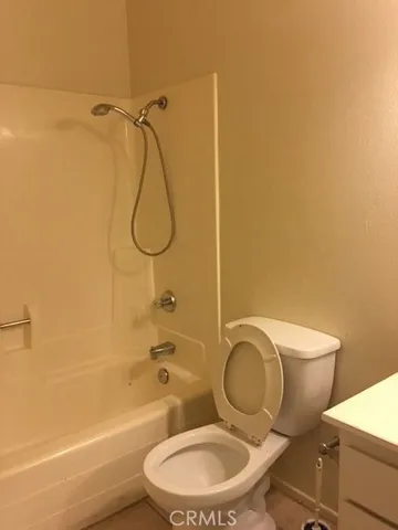 a bathroom with a granite countertop toilet sink and shower