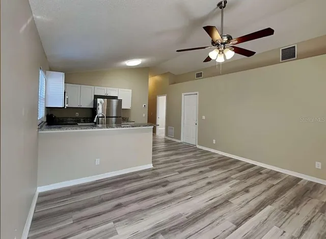 a view of a kitchen with a sink cabinet and a ceiling fan