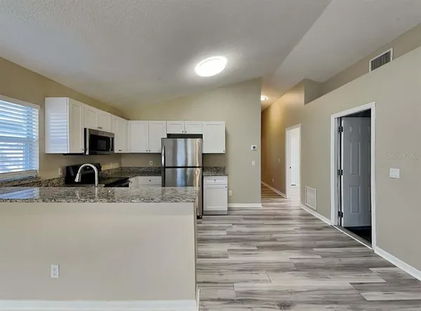 a view of kitchen with stainless steel appliances kitchen island sink refrigerator and stove