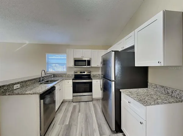 a kitchen with a sink stove and refrigerator