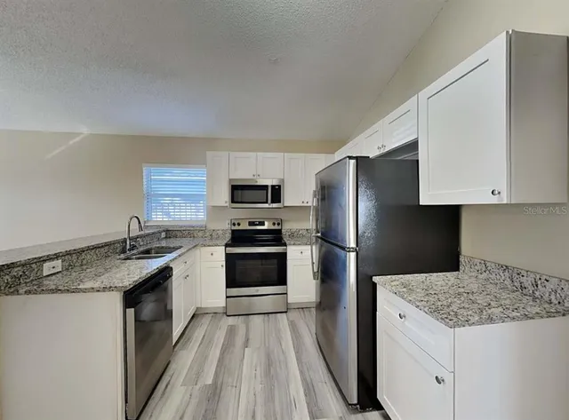 a kitchen with a sink stove and refrigerator