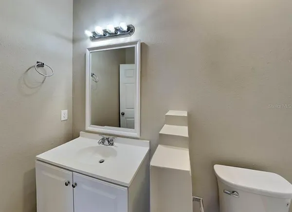 a bathroom with a sink toilet and mirror