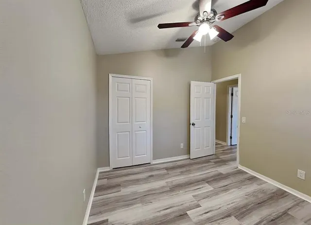 en empty room with wooden floor fan and window