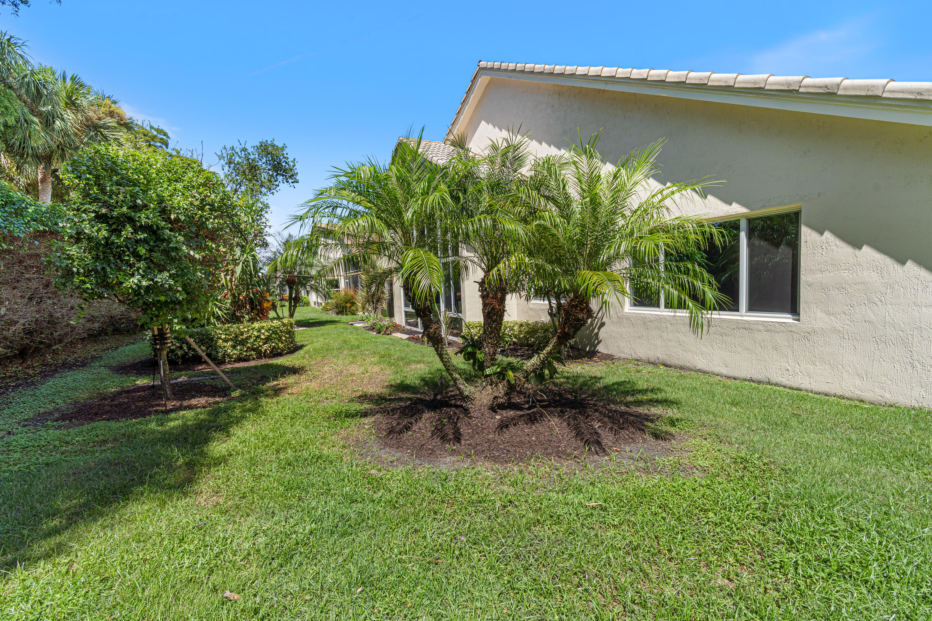 7296 Falls Road East Boynton Beach, FL 33437 - Photo 25 of 25 a view of a backyard with plants and a bench