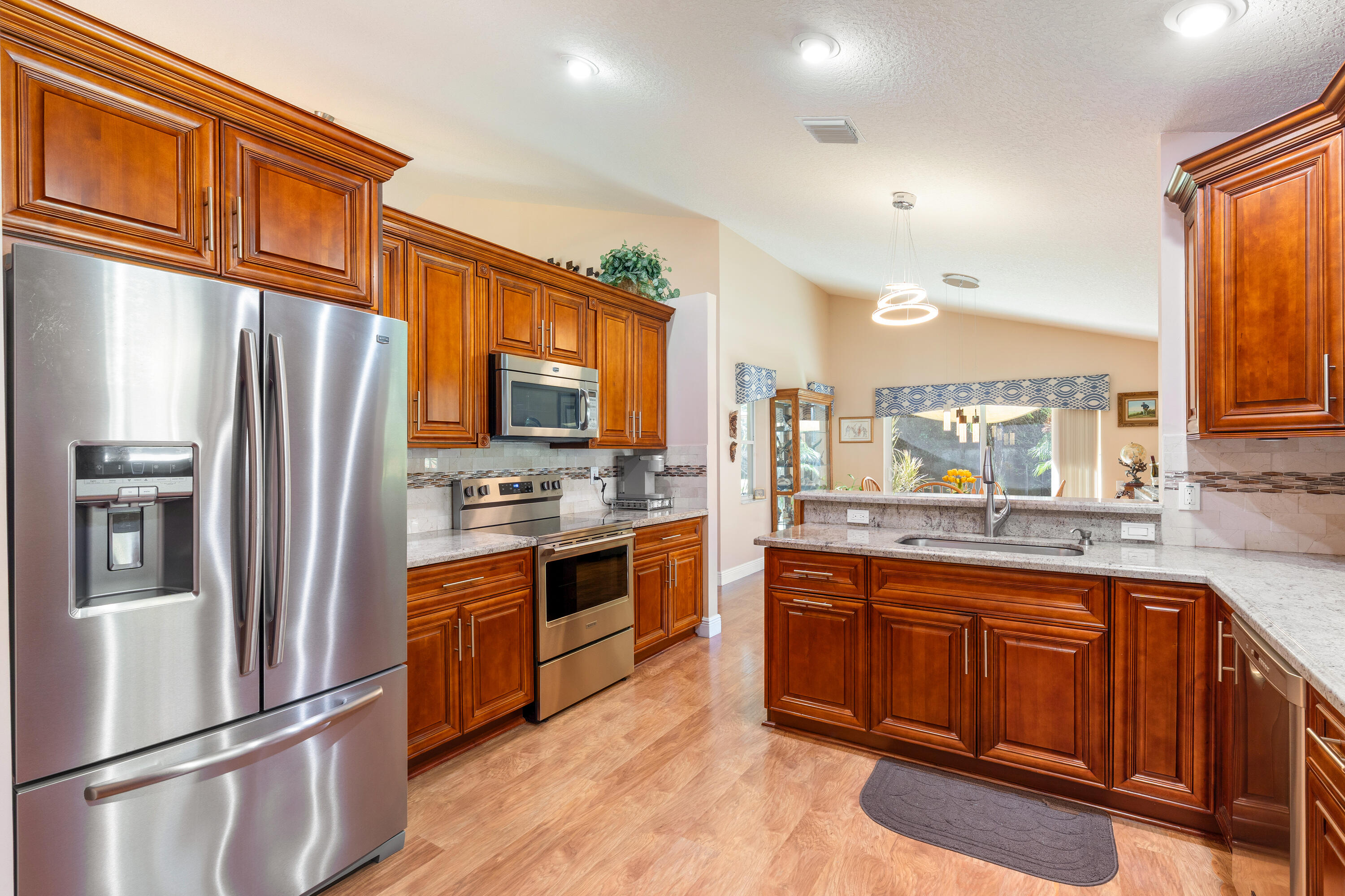 7296 Falls Road East Boynton Beach, FL 33437 - Photo 7 of 25 a kitchen with stainless steel appliances granite countertop a refrigerator a stove top oven a sink and dishwasher