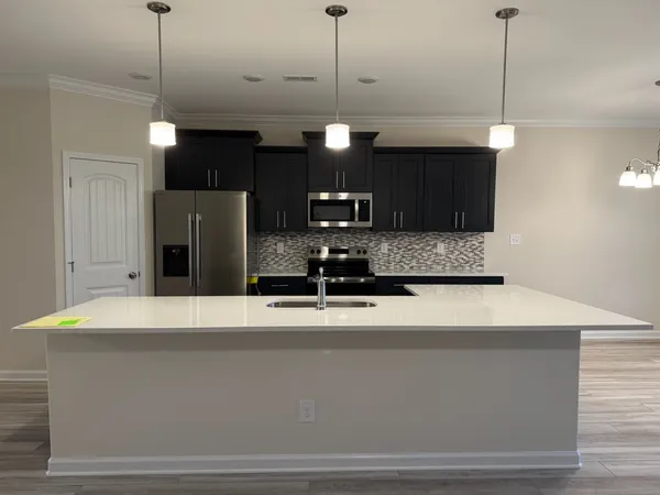 a kitchen with a refrigerator a sink and a lamp