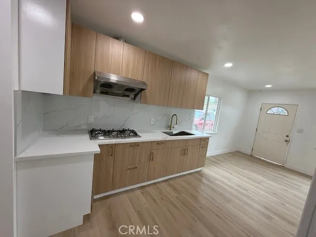 a kitchen with granite countertop a sink stove and cabinets