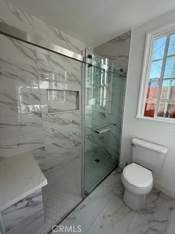 a bathroom with a toilet and a shower