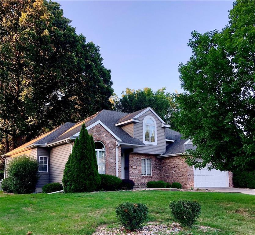 a front view of a house with a yard and trees