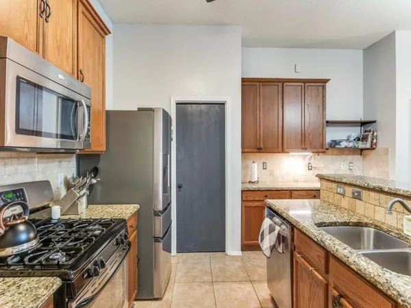a kitchen with stainless steel appliances granite countertop a sink stove and refrigerator
