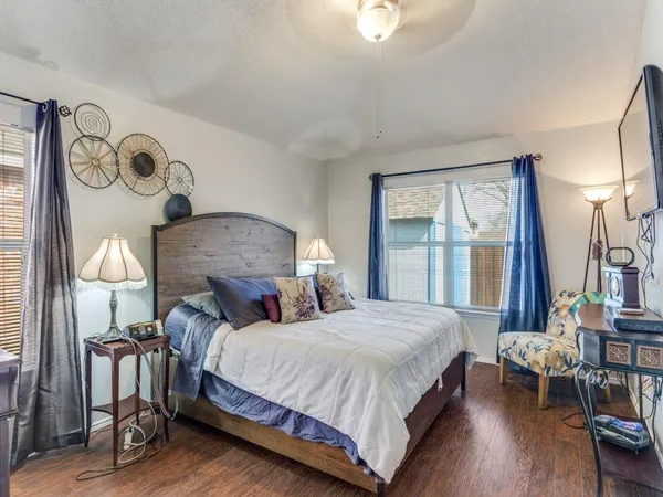 a bedroom with bed and a large mirror next to a window