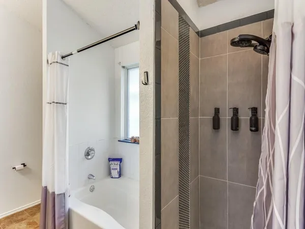 a bathroom with a bathtub and shower