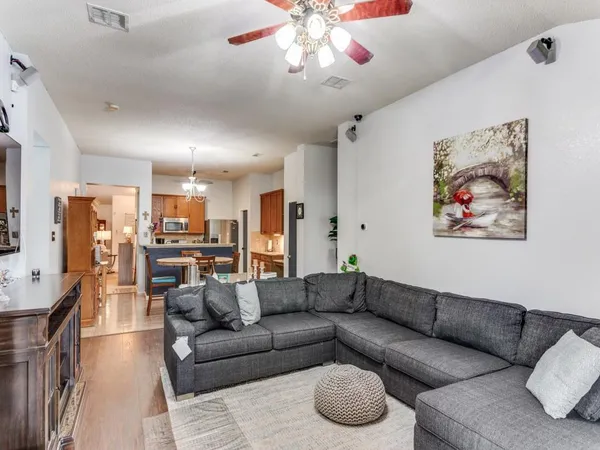 a living room with furniture kitchen view and a chandelier