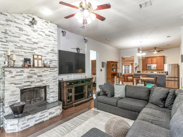 a living room with furniture a flat screen tv and a fireplace