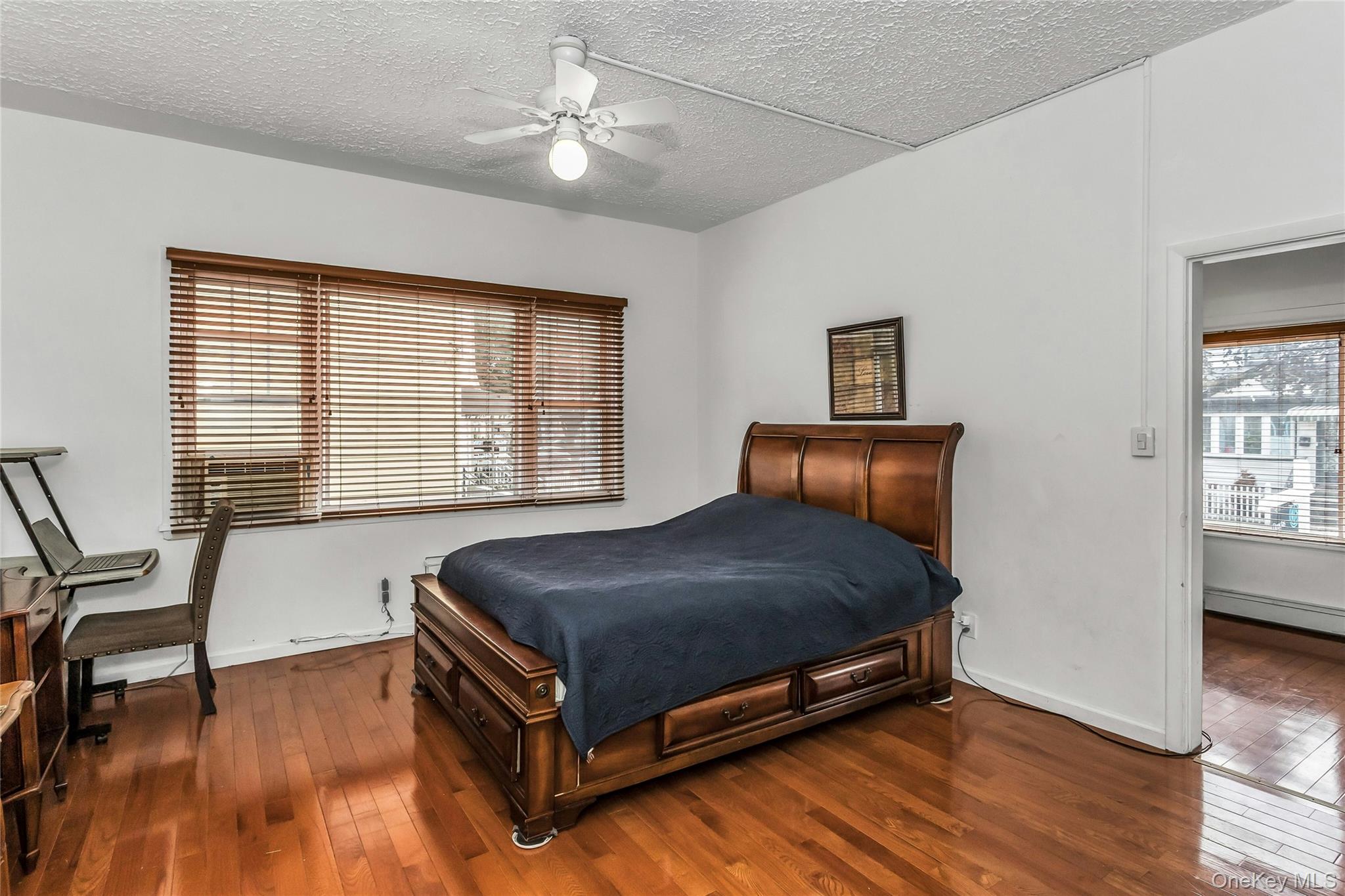91-15 79th Street Queens, NY 11421 - Photo 6 of 11 a bedroom with a bed and wooden floor