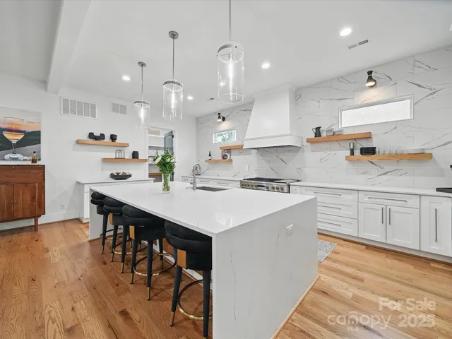a kitchen with white cabinets stainless steel appliances and kitchen island