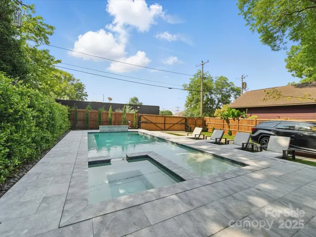 a view of a patio with dining table and chairs with plants and a palm tree