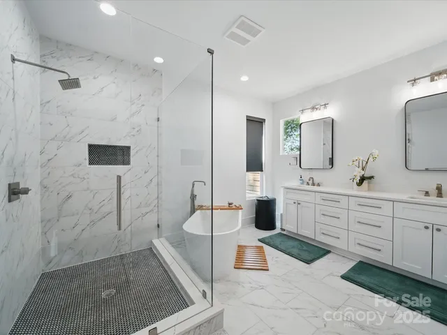 a bathroom with a double vanity sink toilet mirror and shower
