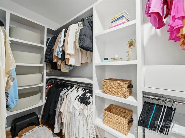 a view of walk in closet with clothes and shoes