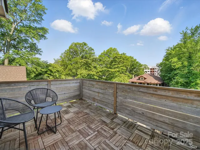 a view of a house with a garage and large tree