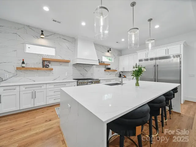 a kitchen with kitchen island a stove a table and chairs in it