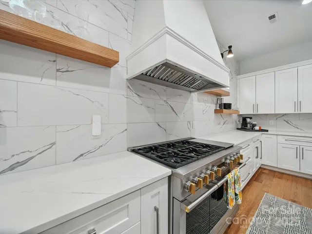 a kitchen with stainless steel appliances granite countertop a cabinets and a stove