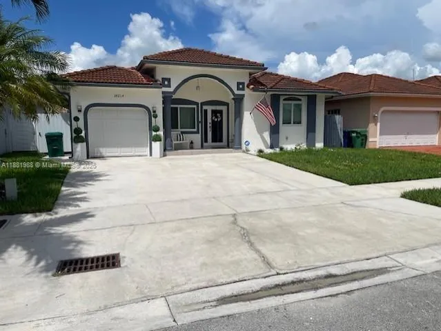 a view of two chairs and table in the patio