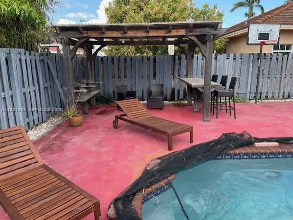 a patio with table and chairs with wooden fence