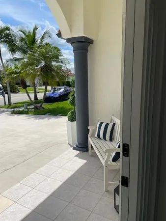 a view of two chairs and table in the patio