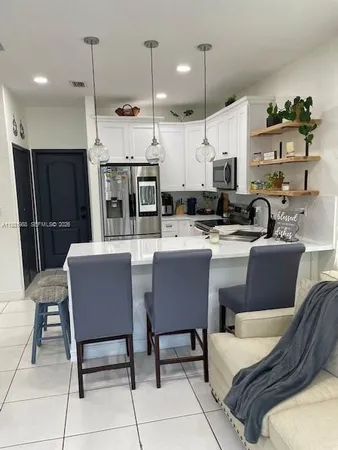 a kitchen with stainless steel appliances kitchen island granite countertop a sink and chairs