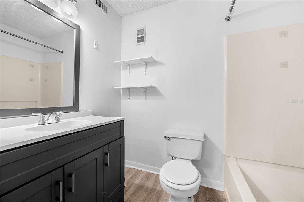 3921 Southwest 34th Street, Unit 208 Gainesville, FL 32608 - Photo 25 of 33 a bathroom with a granite countertop toilet sink and mirror