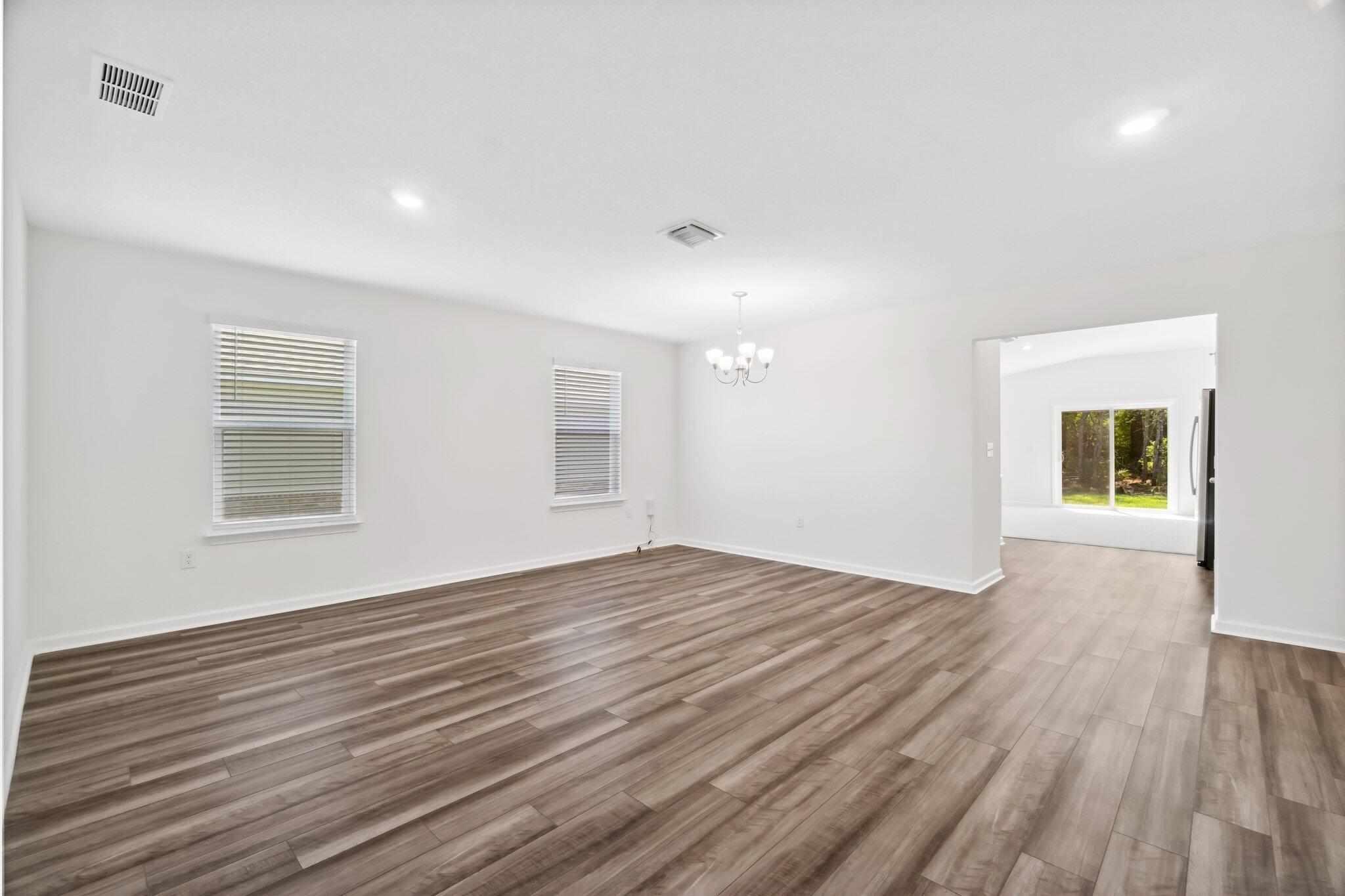 720 Riverwalk Circle Freeport, FL 32439 - Photo 7 of 34 a view of an empty room with wooden floor and a window