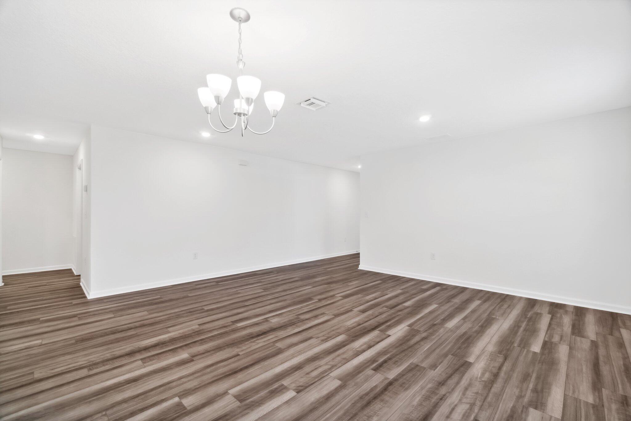 720 Riverwalk Circle Freeport, FL 32439 - Photo 8 of 34 a view of an empty room with wooden floor and a window