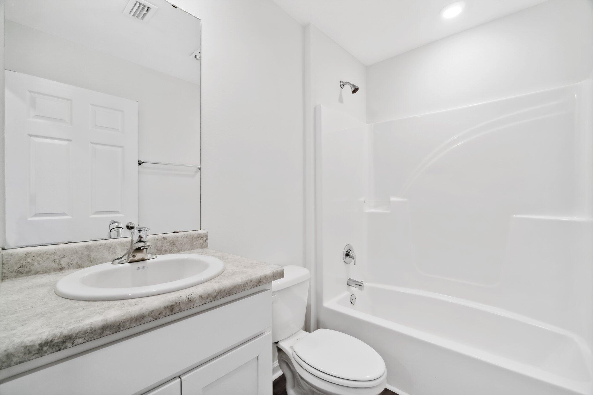 720 Riverwalk Circle Freeport, FL 32439 - Photo 9 of 34 a bathroom with a granite countertop sink a toilet and bathtub