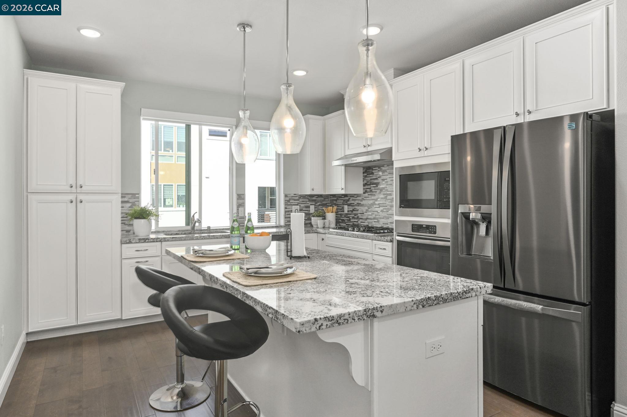 3923 Meridian Street Dublin, CA 94568 - Photo 15 of 39 a kitchen with stainless steel appliances granite countertop a refrigerator a sink a stove a dining table and chairs