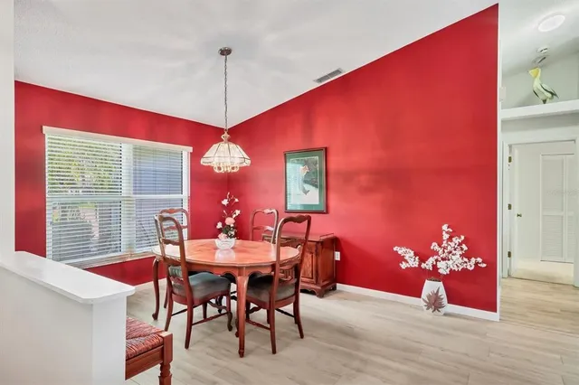 a dining room with furniture a chandelier and wooden floor